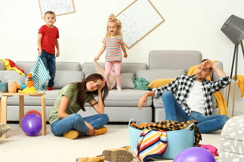 frustrated parents and their mischievous children in messy room