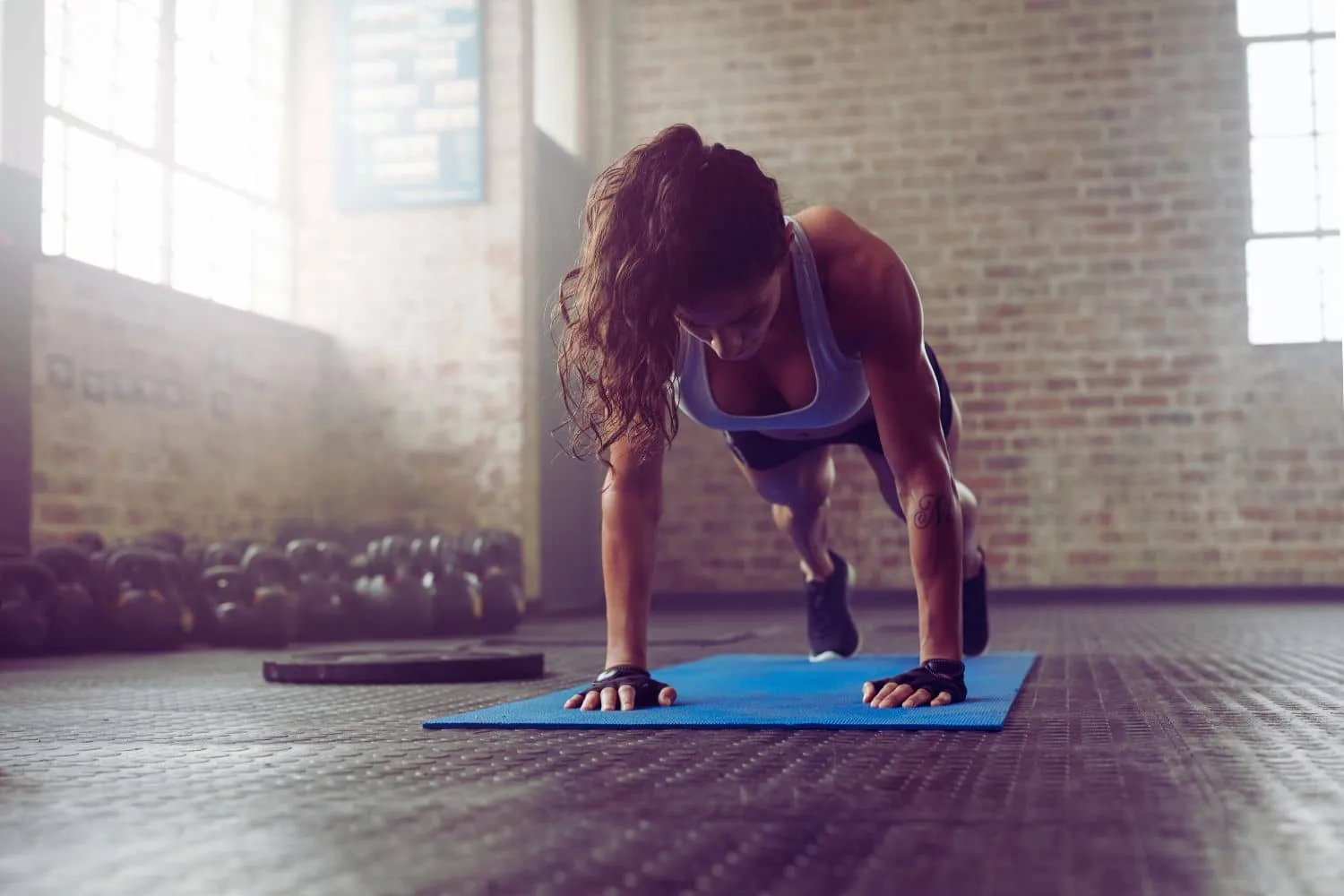 Une personne effectue des Mountain Climbers, un exercice de gainage dynamique impliquant les abdominaux, sous la supervision d'un coach sportif. Cet exercice intense permet de renforcer les muscles de la sangle abdominale et d'améliorer la stabilité du corps. Suivez les conseils de notre coach pour développer vos abdominaux efficacement grâce au Mountain Climber.